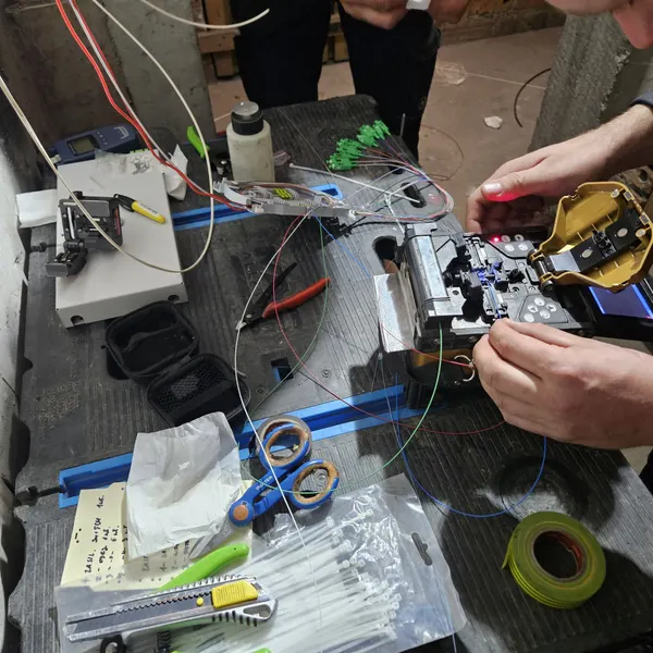 Technik CityNet spawa włókna światłowodowe podczas montażu przyłącza abonenckiego (2025).
