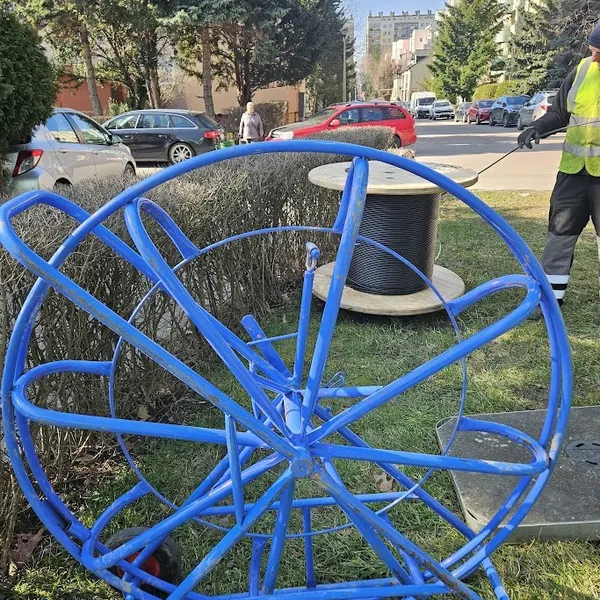 Monter CityNet rozwija kabel swiatlowodowy z bebna na osiedlu w rejonie ul. Swiadka w Rzeszowie — wymiana starej sieci miedzianej na swiatlowod.
