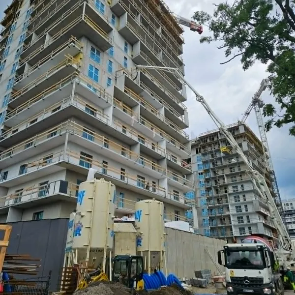 Wysoki budynek mieszkalny w budowie na osiedlu Dzielnica Parkowa w Rzeszowie, doprowadzany do sieci swiatlowodowej CityNet — betonowanie i roboty na ostatnim etapie inwestycji.