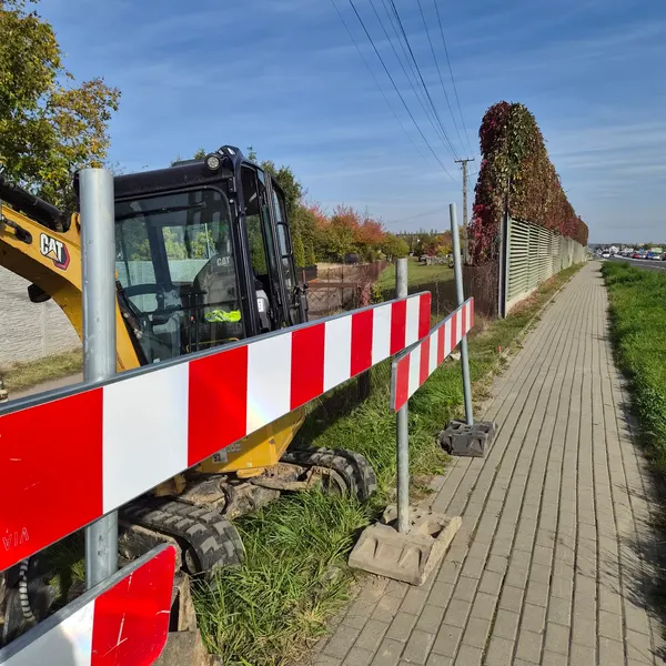 Koparka przy zabezpieczonym miejscu budowy sieci Citynet w pasie DK94