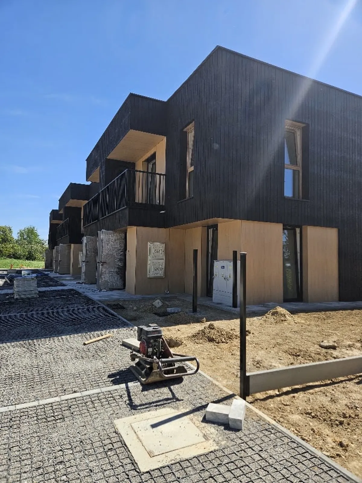 Prace przy nawierzchni na osiedlu BlackWood w Krasnem — segmenty z czarną elewacją podłączane do sieci światłowodowej CityNet