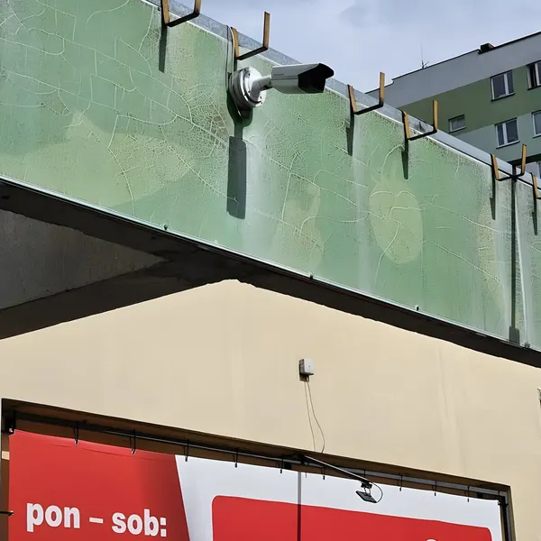 Kamera tubowa monitoringu CityNet na elewacji pawilonu handlowego w Rzeszowie – nadzór nad wejściem i strefą dostaw.