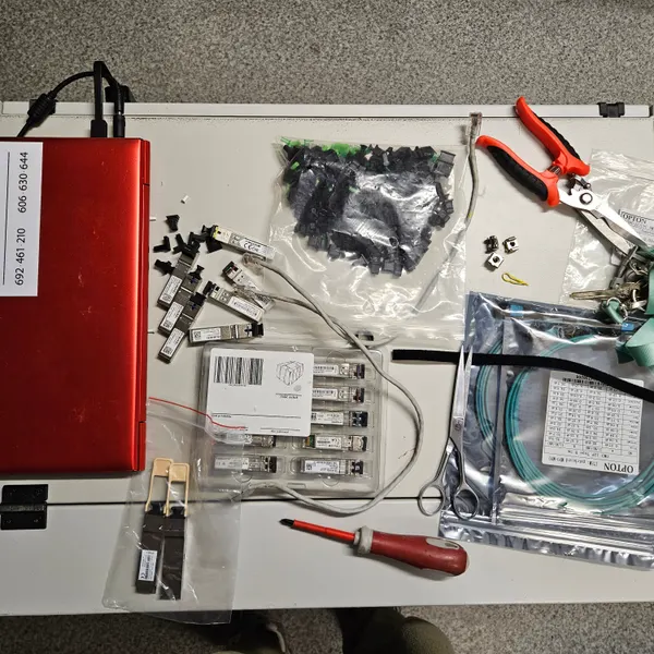 Sprzet CityNet: moduly SFP, patchcordy swiatlowodowe OM3/MPO, zlacza SC/APC i narzedzia montera na stanowisku — wyposazenie do budowy i serwisu sieci swiatlowodowej.